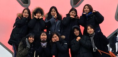 Students pose for a picture during a visit to Dundas Square in Toronto.